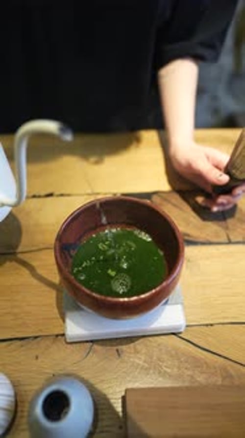 Matcha Process of Making Green Tea in a Bowl on Wooden Table Background