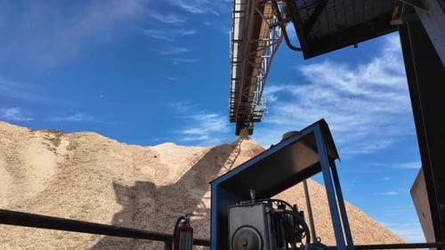 Riesiges Förderband zum Transport von Holzspänen in einer Holzpelletanlage.