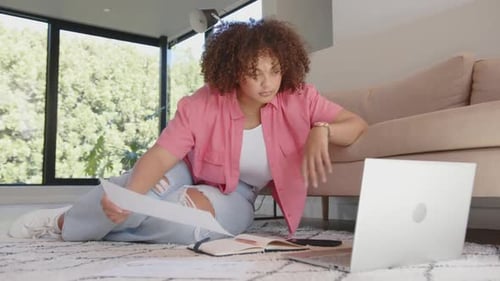 Woman Works From Home with Laptop and Documents
