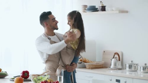 Father and Child Dancing Together in Kitchen
