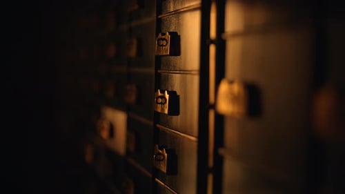 A Row of Safes in a Dark Room Casting Shadows on Hardwood Floor