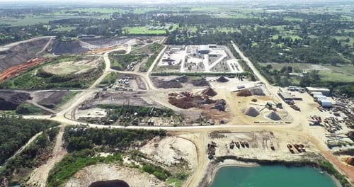 Aerial hyperlapse of industrial quarry site with heavy machinery operating to get their product deli