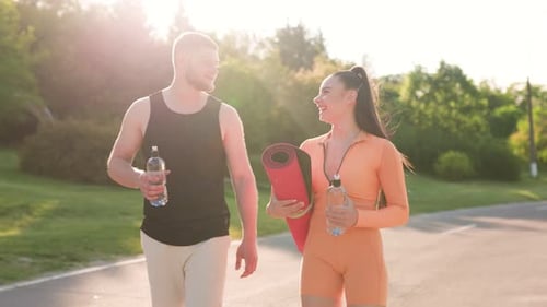Athletic Togetherness Back View of Two Young Adults in Sportswear Chatting Outdoors After Workout