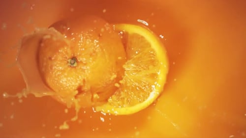 Orange Fruit Falling on Juice with Splash and Divided in Half