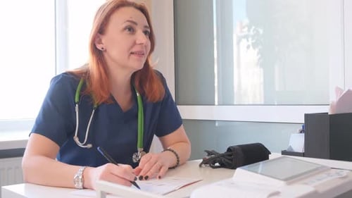 Portrait of a Female Doctor Prescribing Medicine to a Patient in the Office Medical Insurance in the