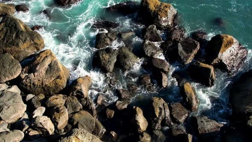 Ocean water waves crashing into rocks.