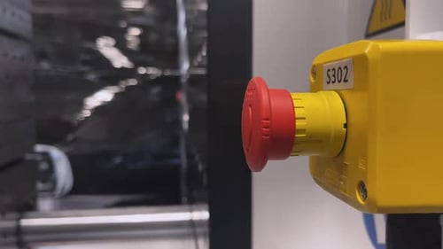Industrial plant worker presses the big red button to stop the Close up