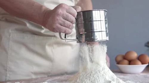 Sifting Flour Onto Countertop to Prepare Baking