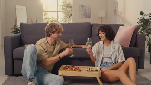 Couple Toasting with White Wine in Cozy Living Room