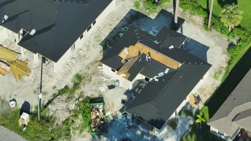 Aerial View of Workers Working on Residential Private Home Covering Wooden Roof with Asphalt