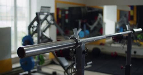 Closeup Barbell with Heavy Weights Lying on Floor in Sport Club
