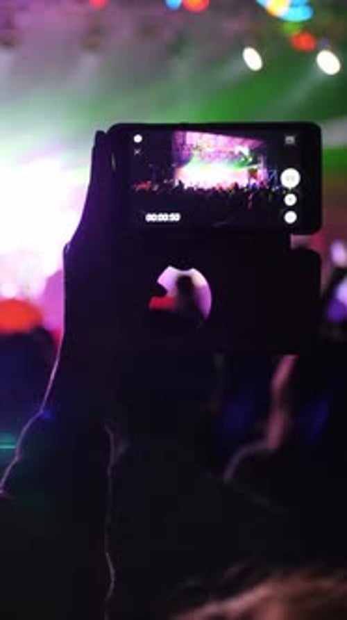 Crowd Enjoys Energetic Performance at Nighttime Festival in Bright Lights