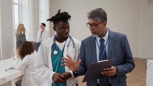 Medical Professionals Discussing Clipboard in Bright Office Setting