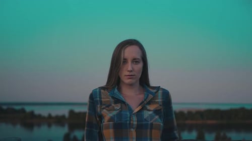 Woman posing against a gradient sky during sunset