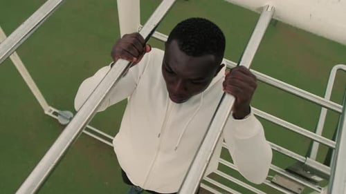 Top view of a man doing pull-ups on a horizontal bar outdoors