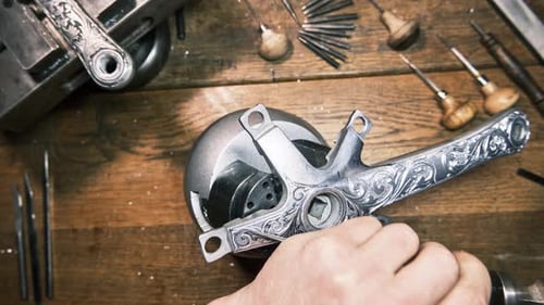 Der Graveur fertigt kunstvolle Ornamente aus Metall von Hand. Gravurverfahren. Traditionelles Kunsthandwerk