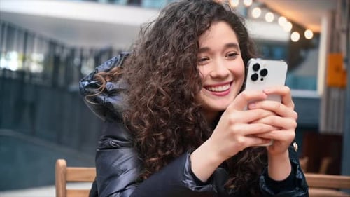 Smiling Woman Using Cell Phone in the City