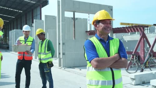 Smiling Construction Worker with Team at Building Site