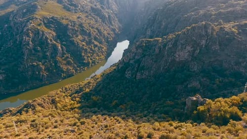 A drone video captures stunning views of mountainous landscapes with a river flowing through the hea