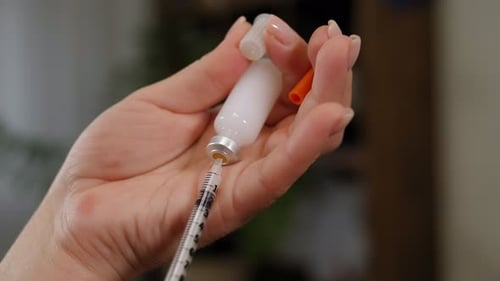 Syringe Extracting Medicine From Glass Vial