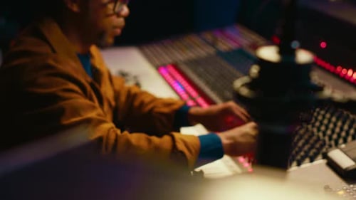 Music Producer Using Audio Mixer in Professional Studio