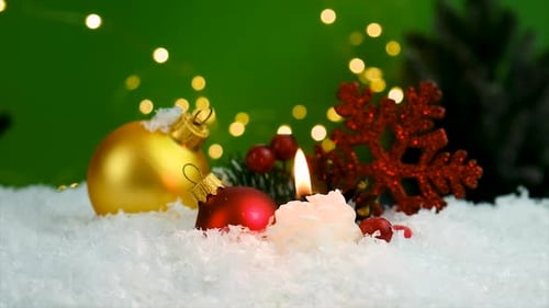 Festive Christmas Ornaments and Candle in the Snow