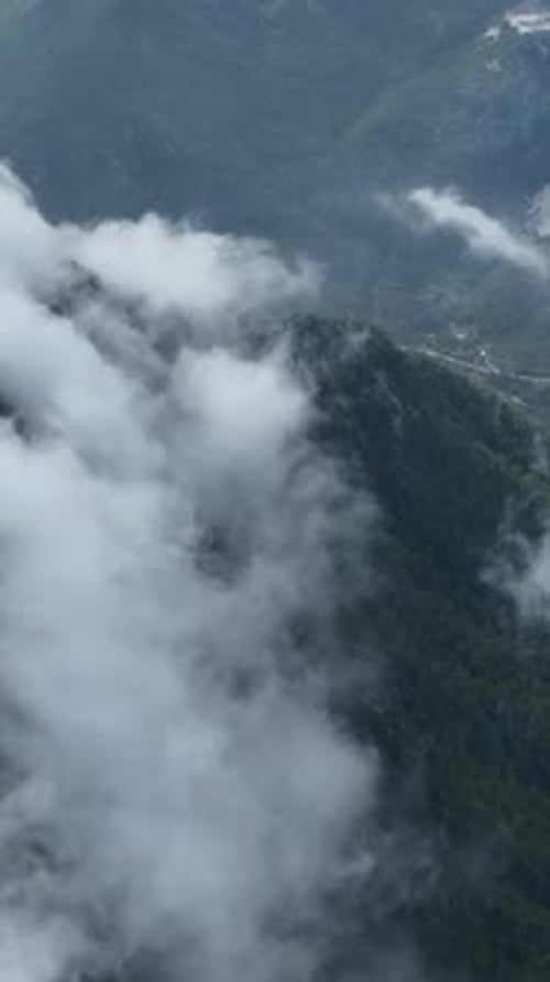 Vertical Video Aerial Perspective of CloudAdorned Mountain Landscape Nature's EverChanging Canvas