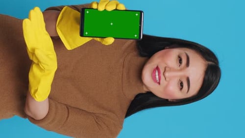 Vertical Video Asian Homemaker Holding Chroma Key Mock Up Mobile Phone with Greenscreen Display