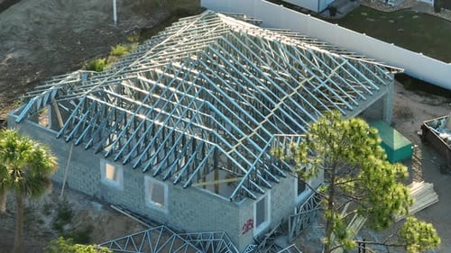 Vue du dessus de l'assemblage du toit fabriqué à partir d'une charpente en acier sur une maison inachevée située en dessous