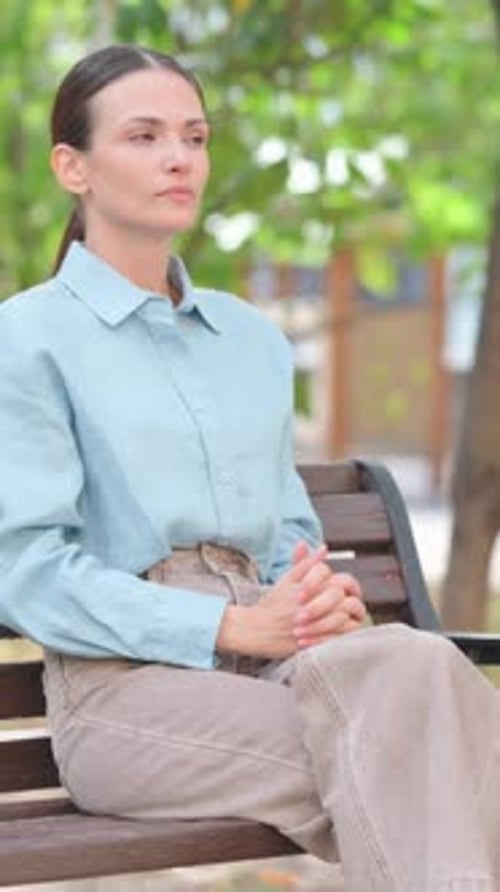 Woman Checking Her Watch While Sitting on Bench