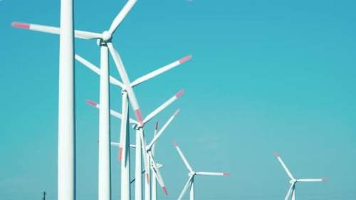 Large rotating wind turbine blades against the blue sky