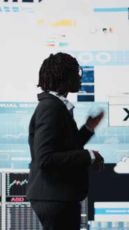 Vertical Video Business Manager Showing Graphs on Digital Screens at Event