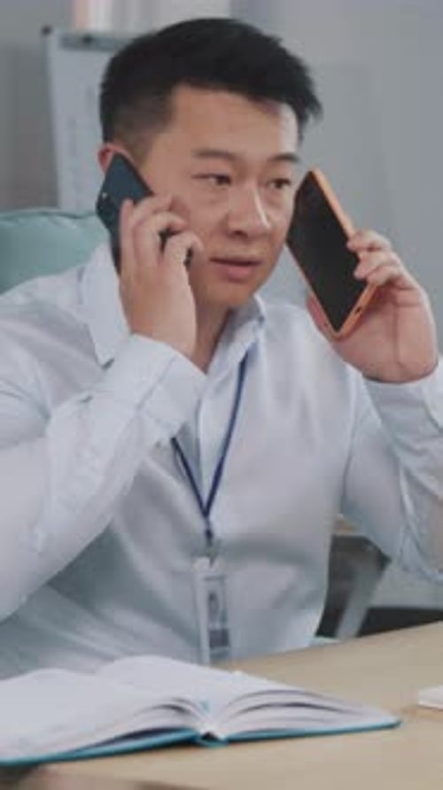 Man Talking on Phone at Desk in Office