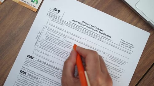 Un employé de bureau remplit une demande de numéro d'identification fiscale et de certification à l'aide d'un stylo