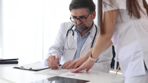 Working with the documents. Two doctors are together in the clinic