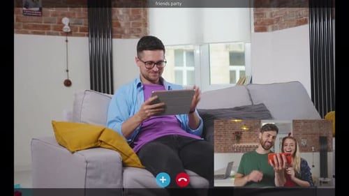 Man Video Calling Friends on Tablet at Home