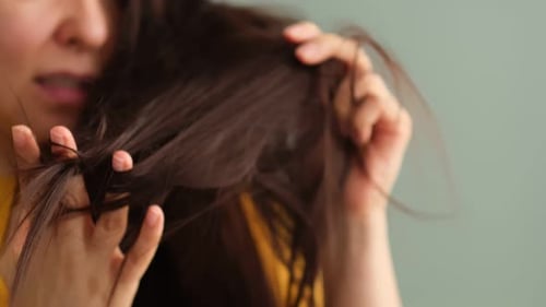 Woman Examining Dry Ends of Brown Tangled Hair