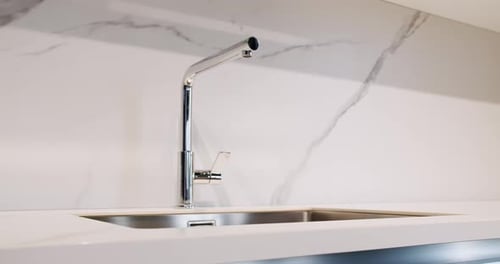 Modern Sink in Clean Kitchen with Marble Countertops