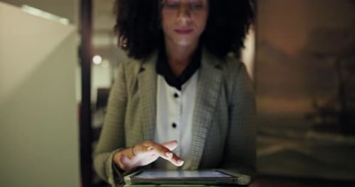 Woman Works on Tablet Device in Office at Night