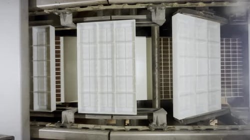 Des moules en plastique blanc ont été transformés dans une usine sur une chaîne de montage produisant de petits ateliers dans une usine.