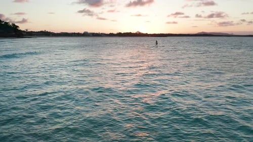 Paddle Boarder at Sunset on a Calm Ocean