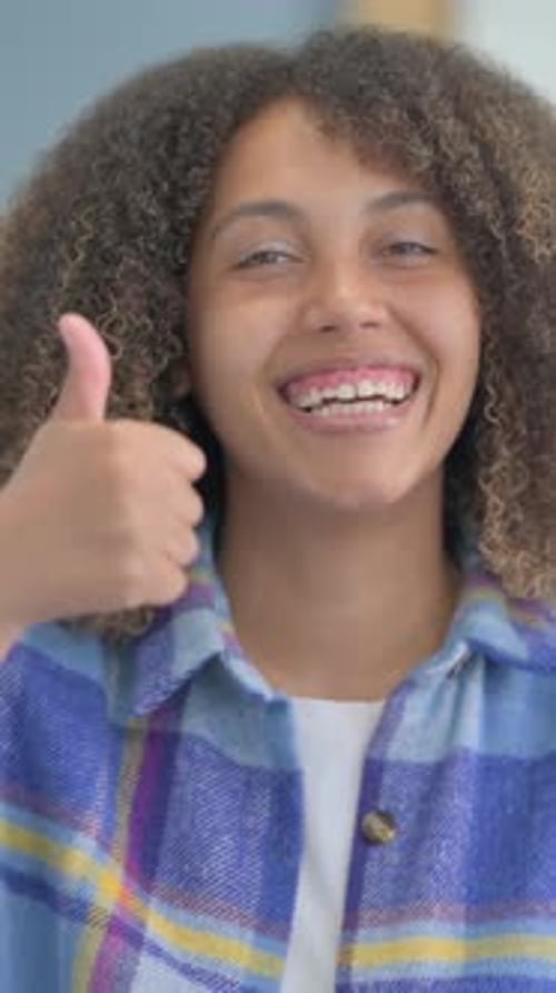 Smiling Young Woman Gives Thumbs Up Approval
