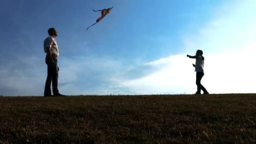 Father and Daughter Flying Kite on Open Field at Sunset, Steadicam