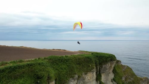 Unrecognizable Skydiver With Parachute Flies Against Blue Sky