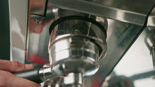 Pouring coffee flows from the machine into the cup making hot drink using the filter holder freshly