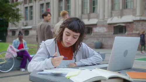 College Girl Studying with Laptop Outdoors on Campus