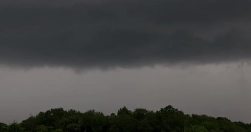 Dark Clouds Above Hill of Trees