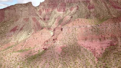 Luftaufnahme der unbefestigten Straße mit Butte Mesa Flat Top Mountain an einem schönen Tag in der Wüste im Südwesten Colorads