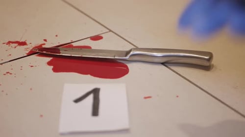 A bloody weapon being numbered and tagged for evidence in a case - Close up