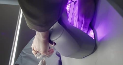 Woman Drying Her Nail Polish with Uv Lamp